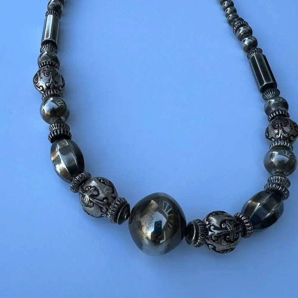 Tarnished silver color beaded necklace. Multiple shapes & sizes of silver color